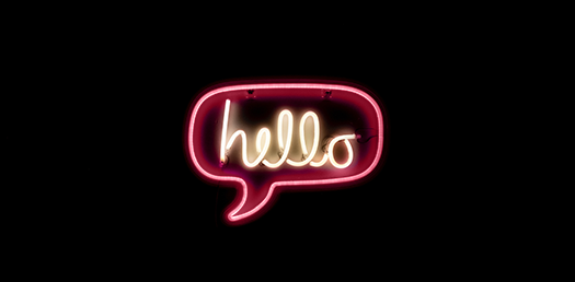 Rosa neonskylt i form av en pratbubbla med texten "Hello" skrivet i mitten